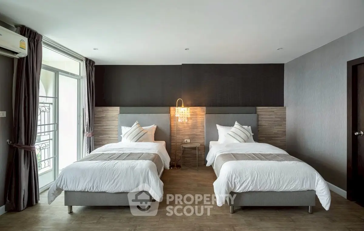 Modern bedroom with twin beds and stylish decor in a contemporary apartment.