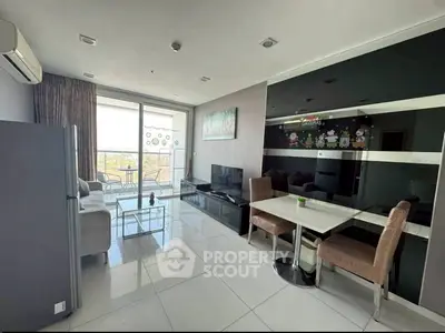 Modern living room with balcony, sleek furniture, and large windows offering a bright and airy atmosphere.