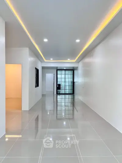 Spacious modern living room with sleek tile flooring and ambient lighting