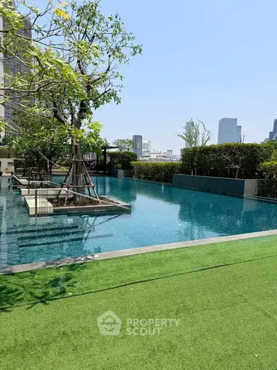 Luxurious rooftop pool with city skyline views and lush greenery, perfect for relaxation and leisure.