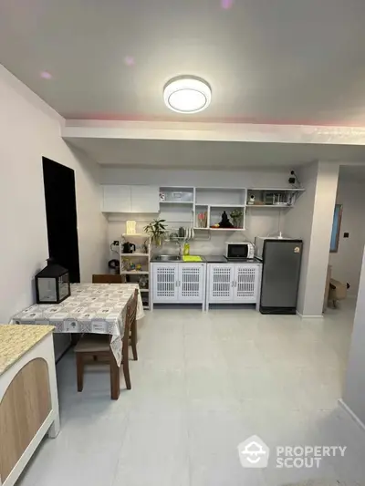 Modern kitchen with sleek white cabinets and compact dining area