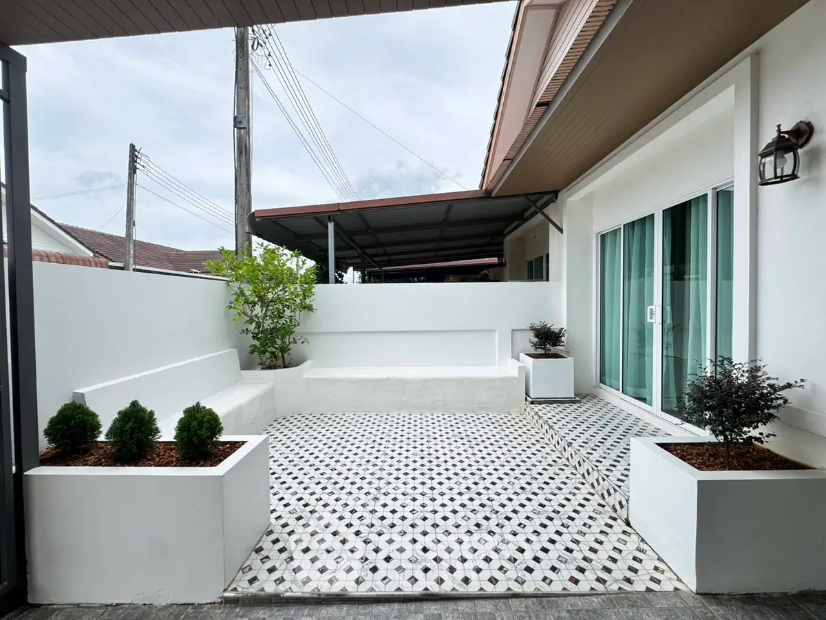 Charming modern patio with stylish tile flooring and lush planters, perfect for outdoor relaxation and entertaining.