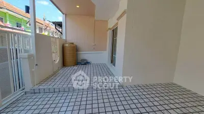 Spacious tiled balcony with privacy walls and outdoor water tank, perfect for relaxation.
