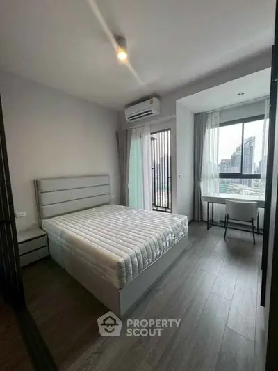 Modern bedroom with city view, featuring a comfortable bed and stylish decor in a high-rise apartment.