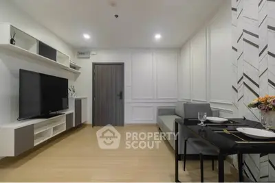 Modern living room with sleek TV setup and elegant dining area in a stylish apartment.
