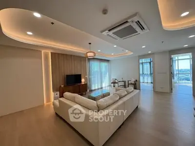 Spacious modern living room with elegant lighting and large windows offering stunning views.