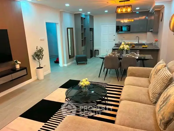 Modern open-layout living room and kitchen with stylish decor and dining area.