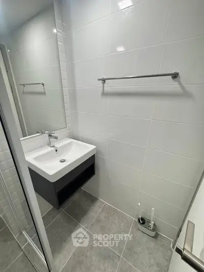 Modern bathroom with sleek sink and tiled walls, ideal for contemporary living.