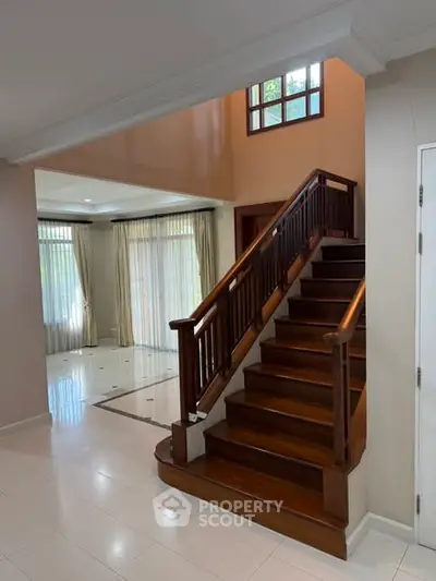 Elegant interior with wooden staircase and bright living area, perfect for modern family living.