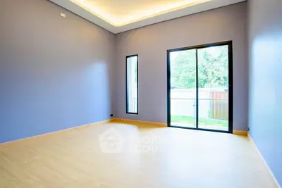 Spacious empty room with large window and modern lighting, perfect for customization.