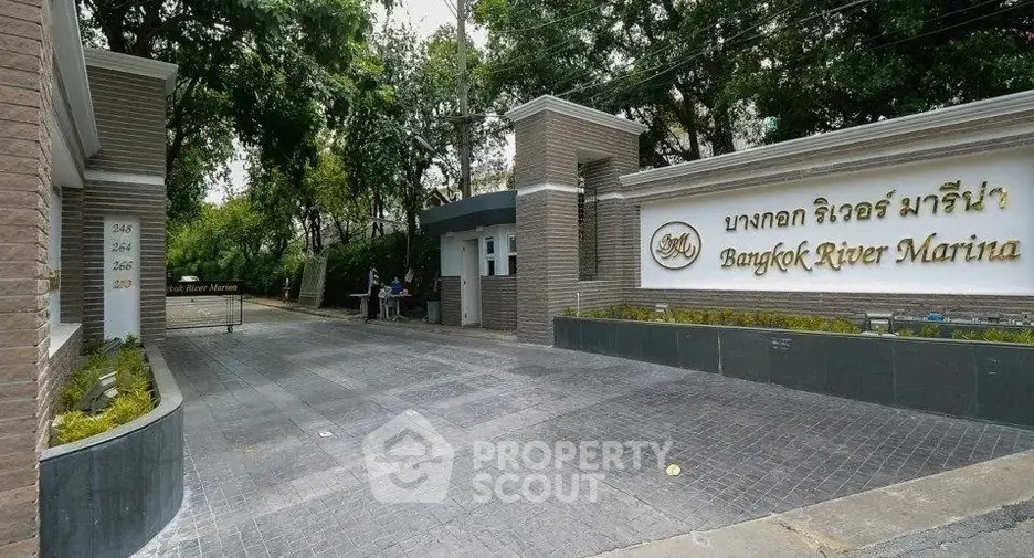 Elegant entrance of Bangkok River Marina with lush greenery and modern signage.