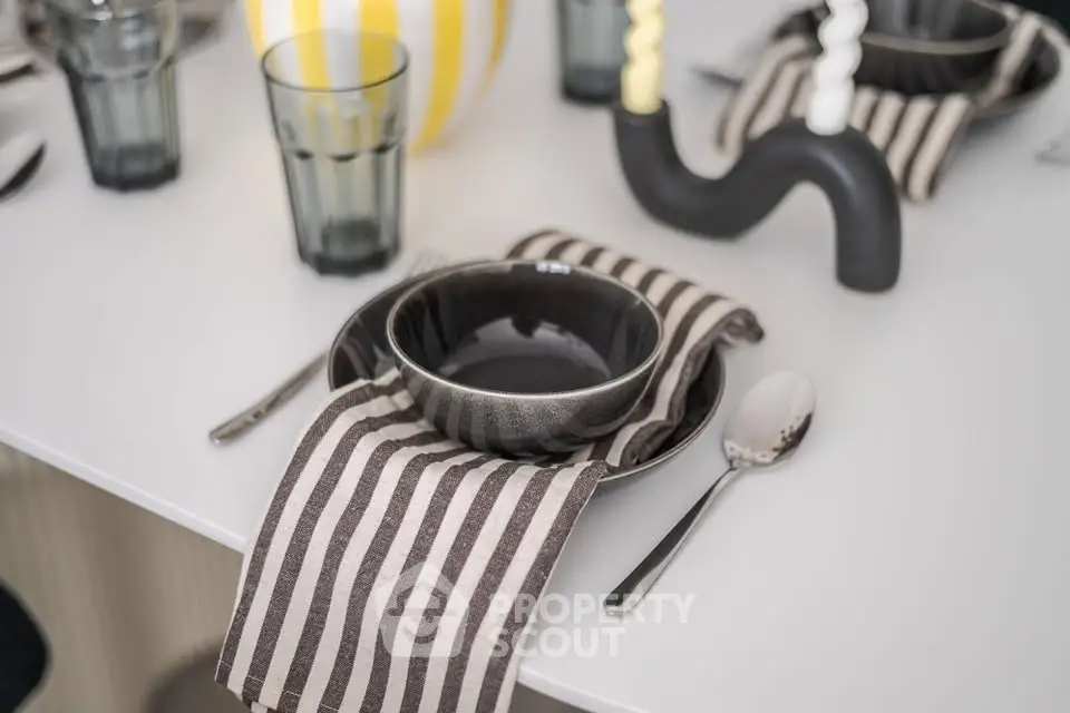 Elegant dining table setting with striped napkins and modern tableware