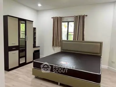 Spacious bedroom with modern furniture and natural light, perfect for comfortable living.