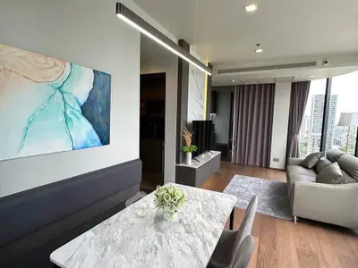 Modern living room with elegant decor and city view, featuring a marble dining table and cozy seating area.