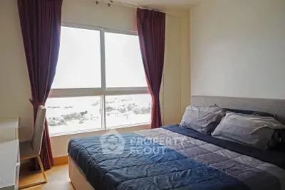 Spacious bedroom with large window and elegant curtains, offering a serene and comfortable living space.