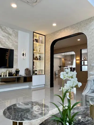 Luxurious modern living room with elegant decor and open layout, featuring marble accents and stylish lighting.