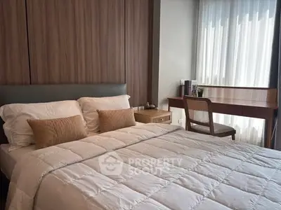 Cozy bedroom with modern decor and natural light, featuring a comfortable bed and stylish desk.