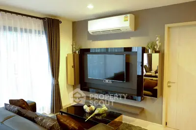 Modern living room with sleek TV setup and air conditioning, perfect for comfortable living.