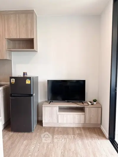Modern apartment interior with compact kitchen and sleek TV setup, perfect for urban living.