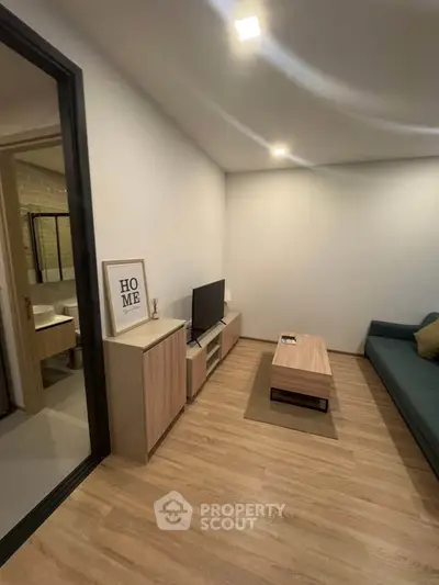 Modern living room with sleek furniture and wooden flooring, perfect for cozy relaxation.