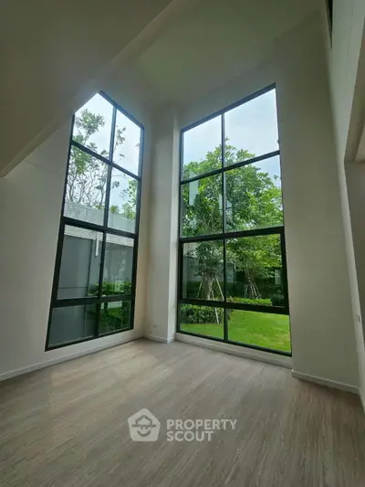 Spacious living room with floor-to-ceiling windows and garden view