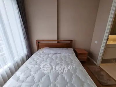 Cozy bedroom with natural light and wooden furniture, perfect for relaxation.