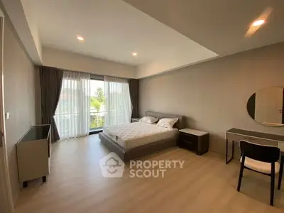 Spacious modern bedroom with large window and elegant furnishings