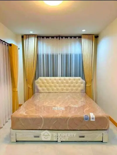 Cozy bedroom with elegant curtains and plush headboard, perfect for relaxation.
