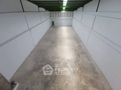 Spacious industrial storage unit with high ceilings and ample lighting.