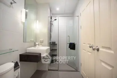 Modern bathroom with glass shower and sleek fixtures in a contemporary home.