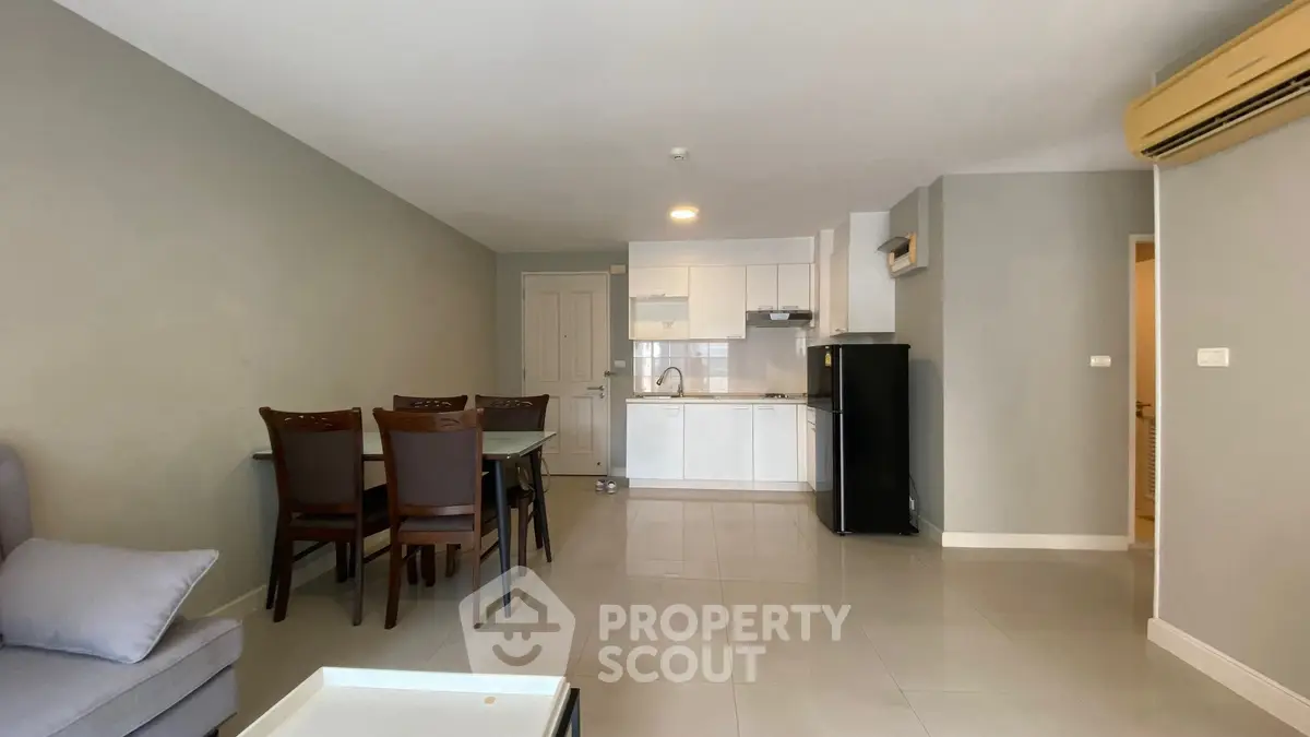 Modern open-plan living room and kitchen with dining area and sleek appliances.