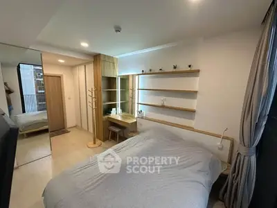 Modern bedroom with sleek design, built-in shelves, and natural light for a cozy living experience.