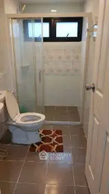 Modern bathroom with glass shower enclosure and tiled flooring