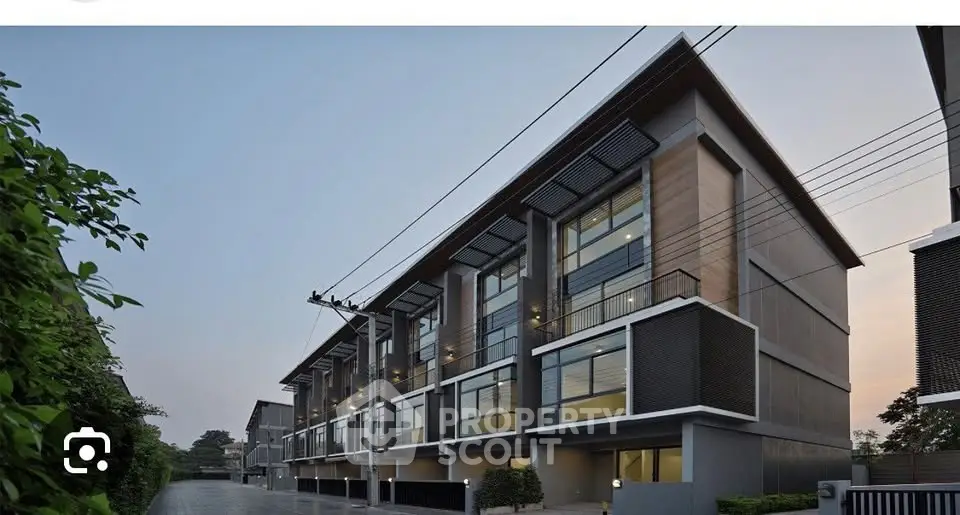 Modern townhouse exterior with sleek design and large windows in a serene neighborhood.