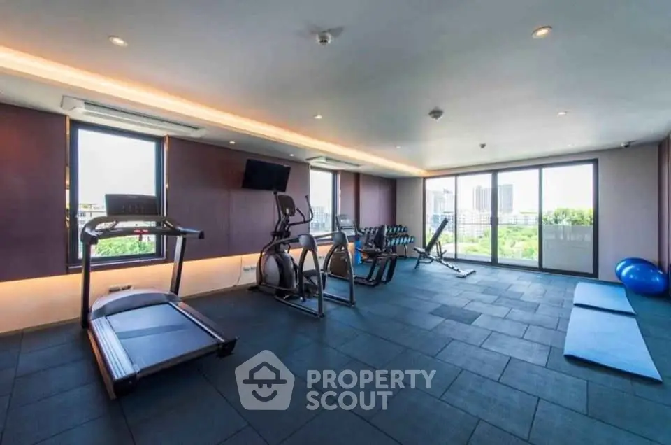 Spacious modern gym with city view and state-of-the-art equipment