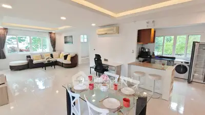 Spacious open-plan living and dining area with modern kitchen in a bright, airy home.