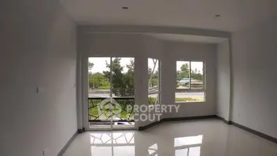 Spacious empty room with large windows and balcony offering scenic views, perfect for customization.
