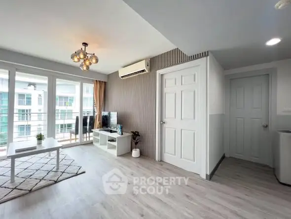 Modern living room with balcony access and stylish decor in a bright apartment.