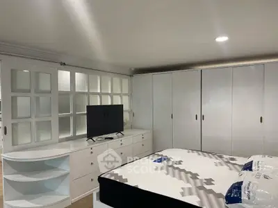 Spacious bedroom with modern furniture and ample storage space