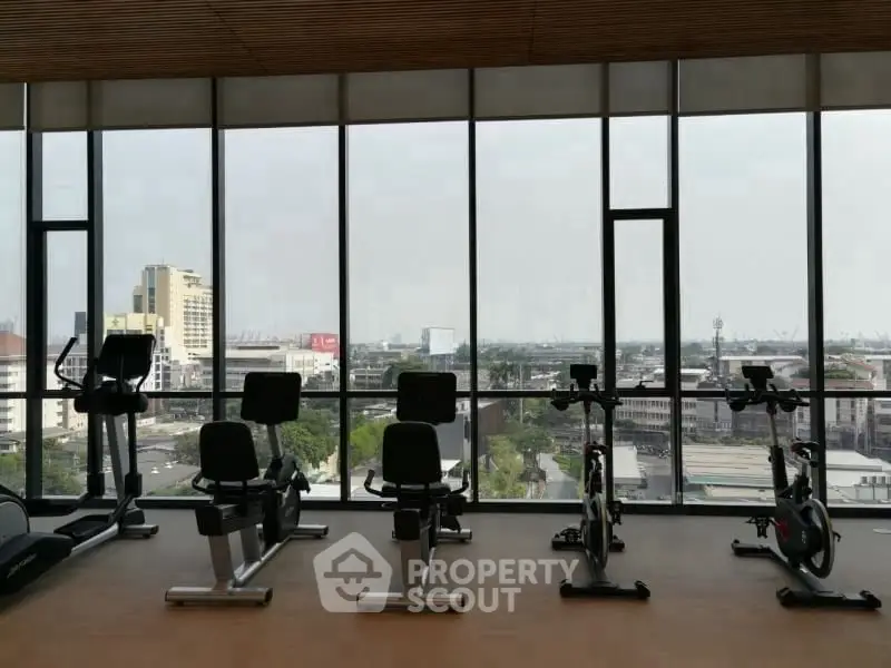 Spacious gym with city view and modern exercise equipment