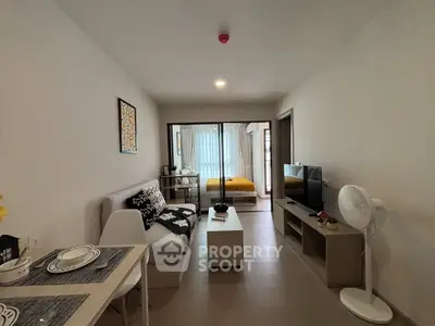 Modern open-plan living room with dining area and view into cozy bedroom