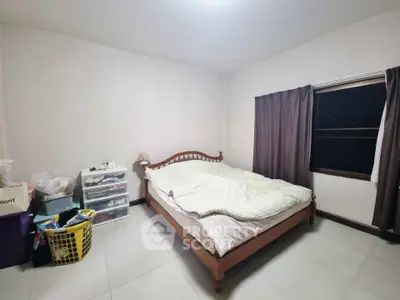 Cozy bedroom with wooden bed frame and ample natural light