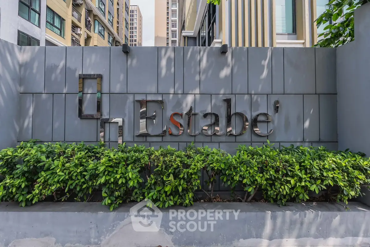 Modern building exterior with stylish signage and lush greenery