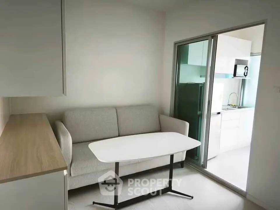 Modern living room with sleek sofa and open kitchen layout, perfect for urban living.