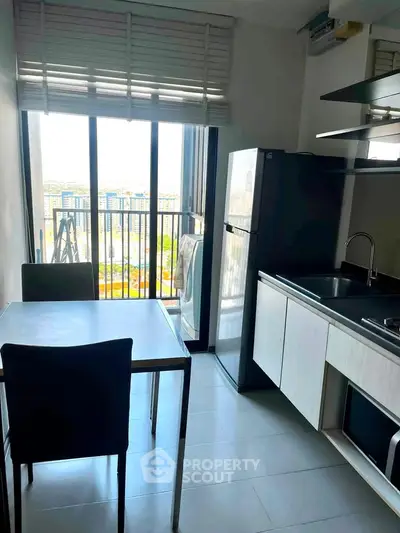 Modern kitchen with dining area and balcony view in urban apartment