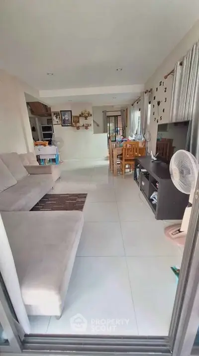 Spacious living room with modern decor and dining area, perfect for family gatherings.