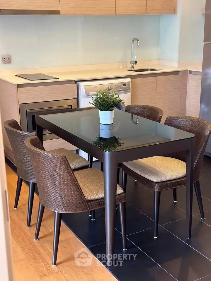 Modern kitchen with sleek dining area and integrated appliances in a stylish apartment.
