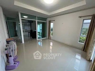 Spacious living room with large windows and garden view, perfect for modern living.