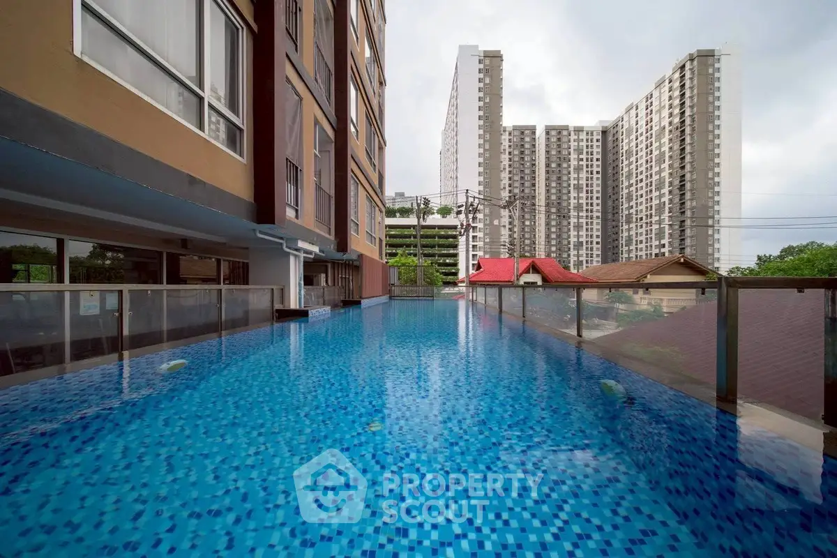 Luxurious rooftop pool with stunning cityscape views in modern high-rise building.