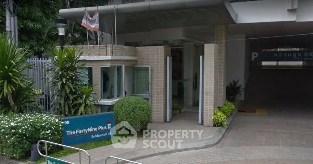 Modern entrance of The FortyNine Plus II with lush greenery and sleek design.